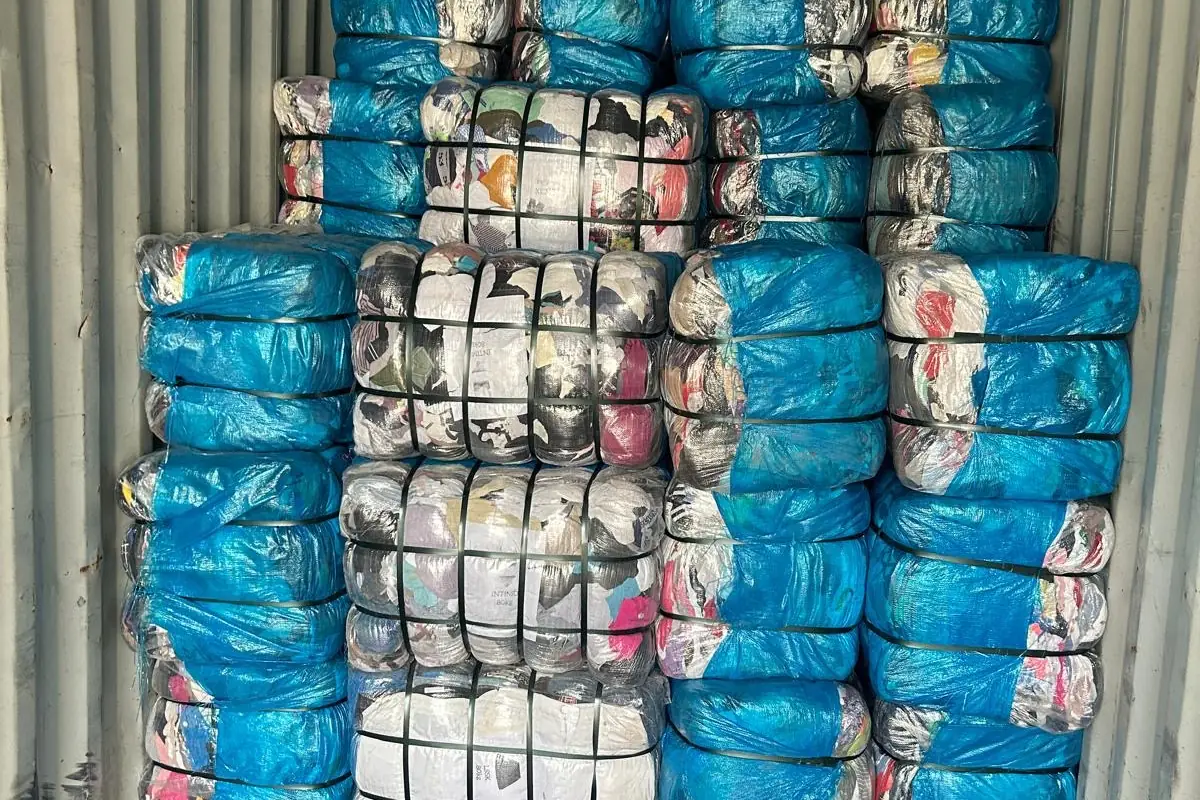 Container loaded with clothing bales wrapped in blue film