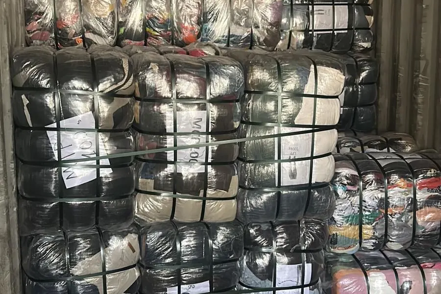 Labelled clothing bales stacked inside a container