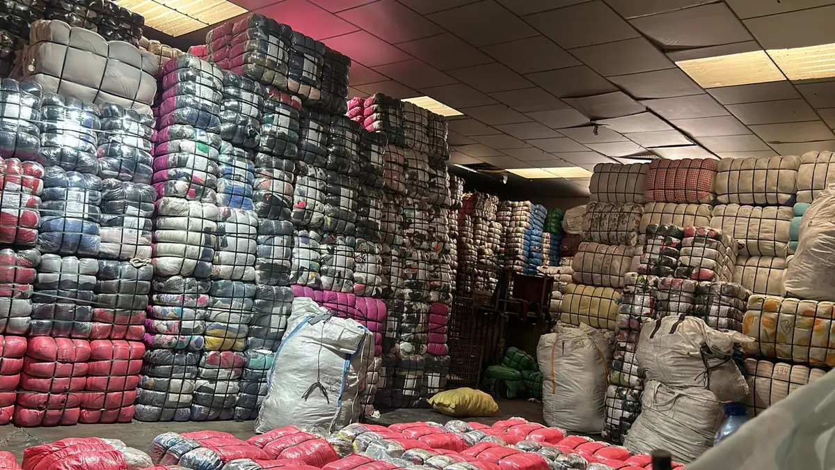 Our warehouse: strapped bales of sorted second-hand clothing stacked to the ceiling